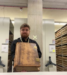 Tom with a book from the Archives