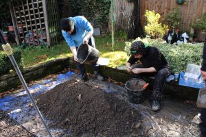 Two people closely examining a spoil heap for finds