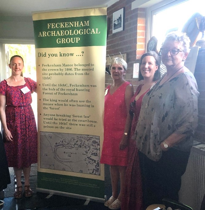 Feckenham community group by a banner about the site