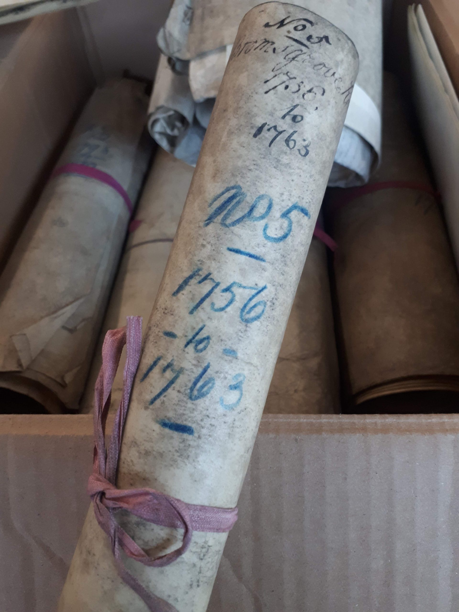 Photo of a rolled document with dates on outside