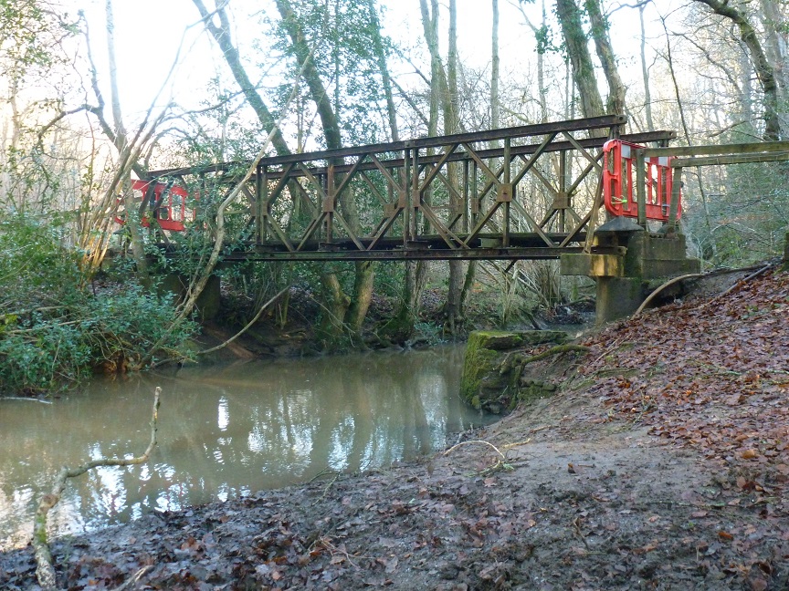 Bailey bridge today across a stream in a wooded area
