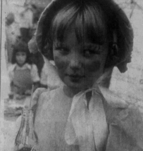 A black and white photograph of a young girl dressed as Aunt Sally.