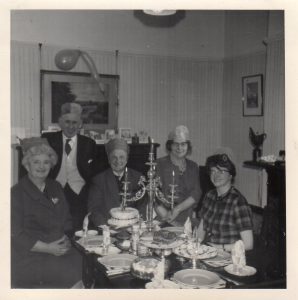 A black and white photograph of a family get together dated circa 1962.