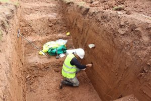 An archaeologist taking OSL samples from alluvium sediment