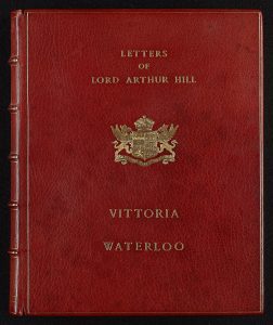 Front cover of a book of letters of Lord Arthur Hill. Red leather with gold lettering and emblem.