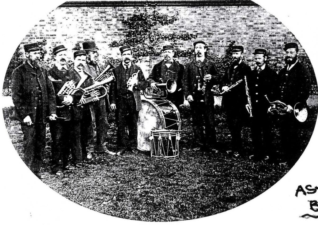 A black and white photograph picturing men from Powick Asylum's Band with various instruments including a large drum, dressed in Edwardian dress