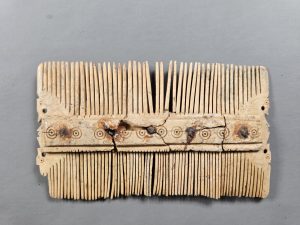 Bone comb with horse head decoration.