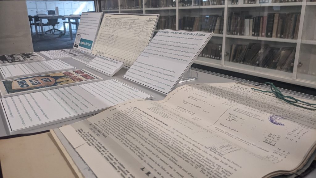 Display of printed material in a glass exhibition case including original paper and board backed file which concerns Bankruptcy records held at Worcestershire Archives and Archaeology Service