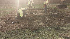 Metal detectorists detecting the surface as each spit is removed by the machine