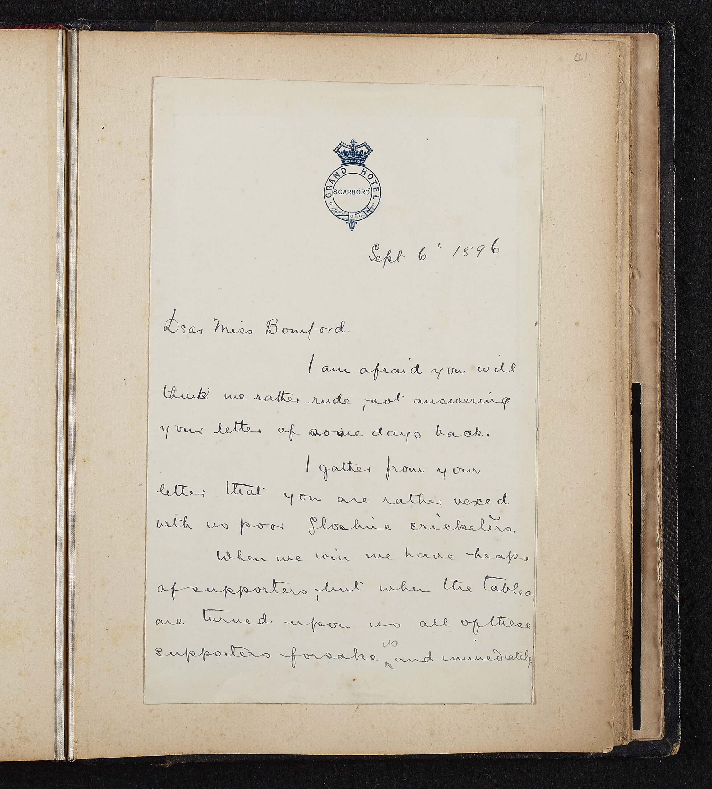Handwritten text, black ink on paper. Paper stuck onto a page of a book. Responding to a letter from Miss Bomford, expressing frustration with "fair weather fans"