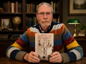 Colour photograph of the author holding a copy of his book.